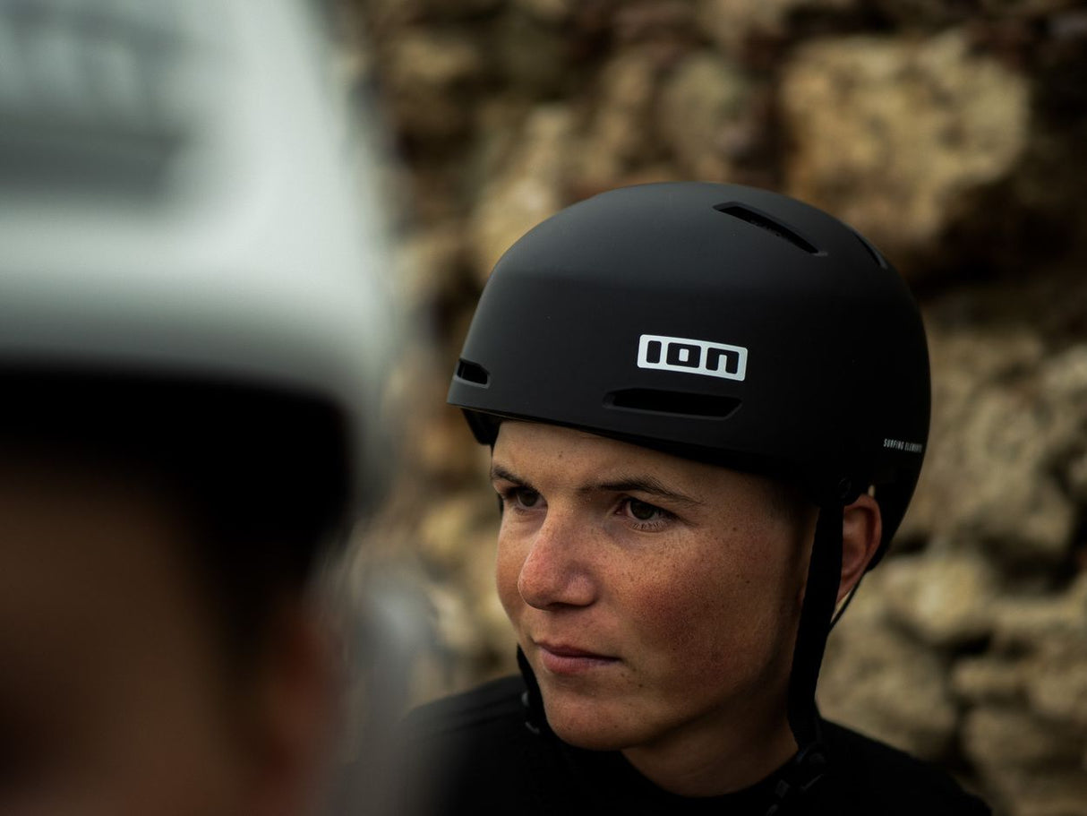 ION Slash Core Helm 2026 in Schwarz mit weißem ION-Logo, Seitenansicht auf Person getragen