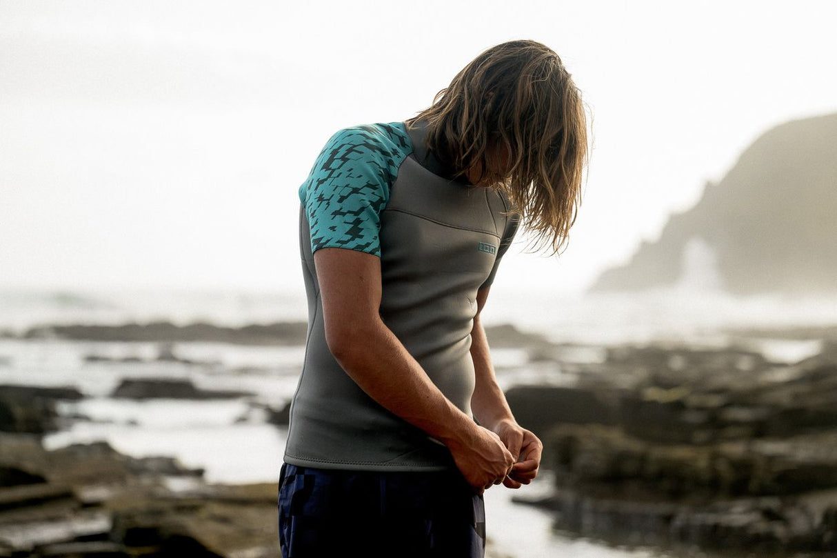 ION Neo Top 2024 Neoprenshirt grau mit türkis gemustertem Arm, Rückansicht am Strand getragen