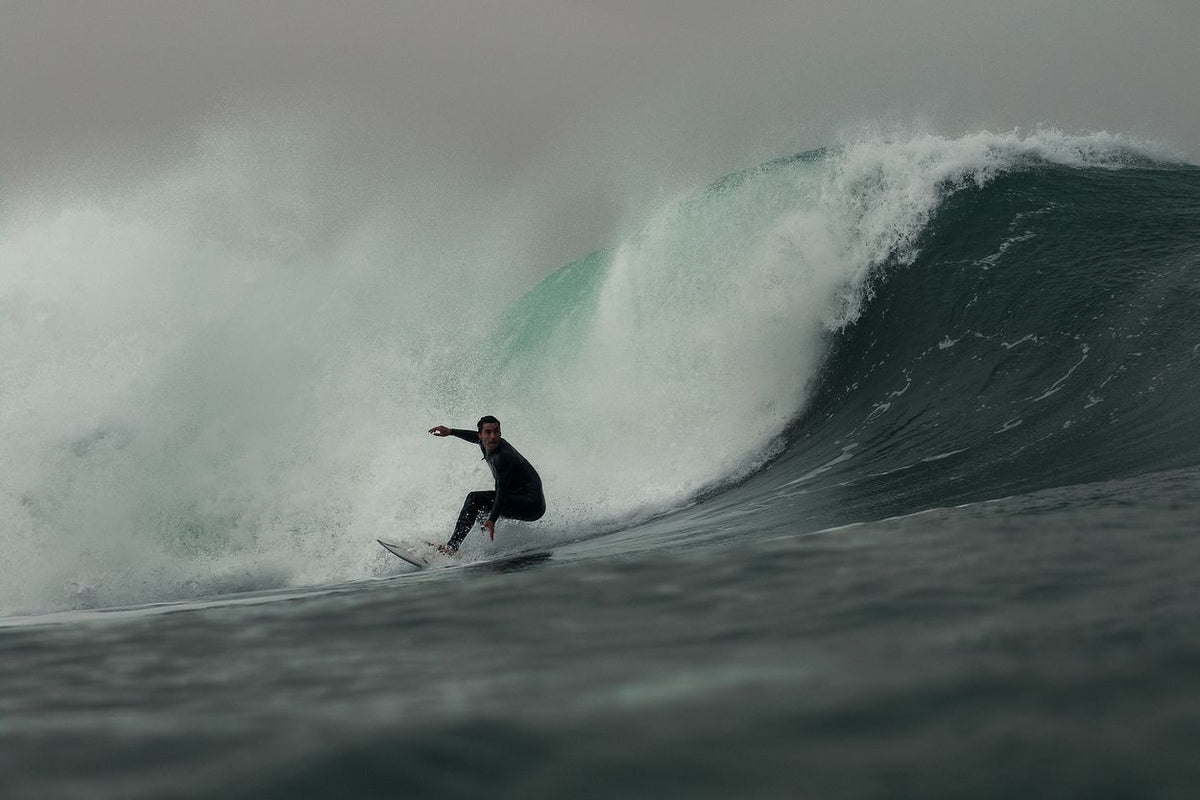 ION Seek Amp 3/2 Front Zip Neoprenanzug in Schwarz, Surfer auf großer Welle in Action-Perspektive