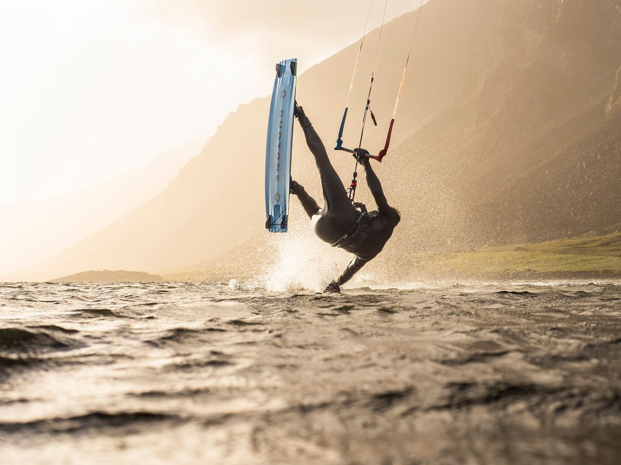 ION Spectre 2026 Kite in Blau, Kitesurfer in Aktion über Wasser mit Bergen im Hintergrund