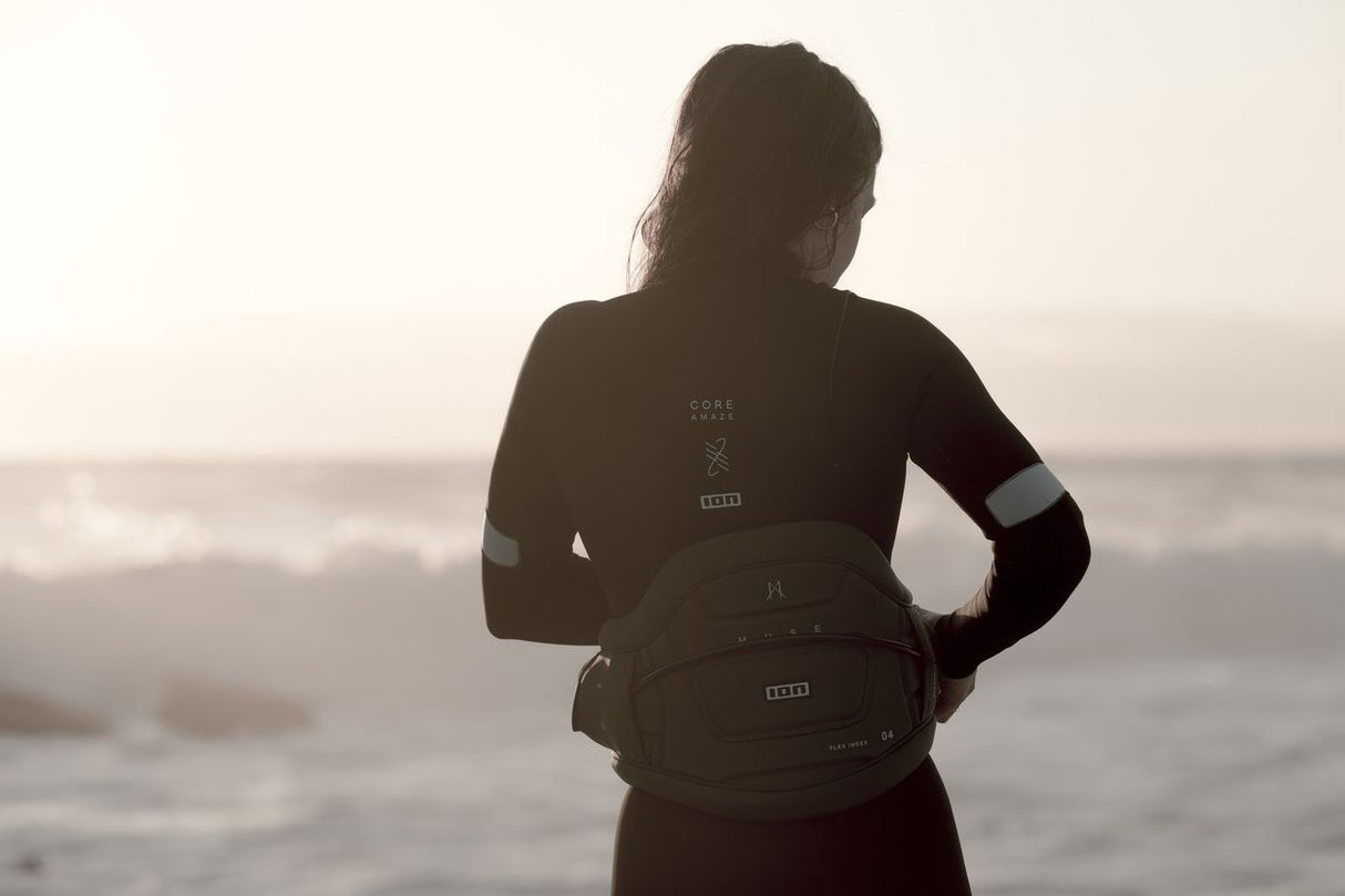 ION Muse Kite Trapez 2026 schwarzes Trapez, getragen von Person am Strand mit Meereshintergrund, Frontalansicht