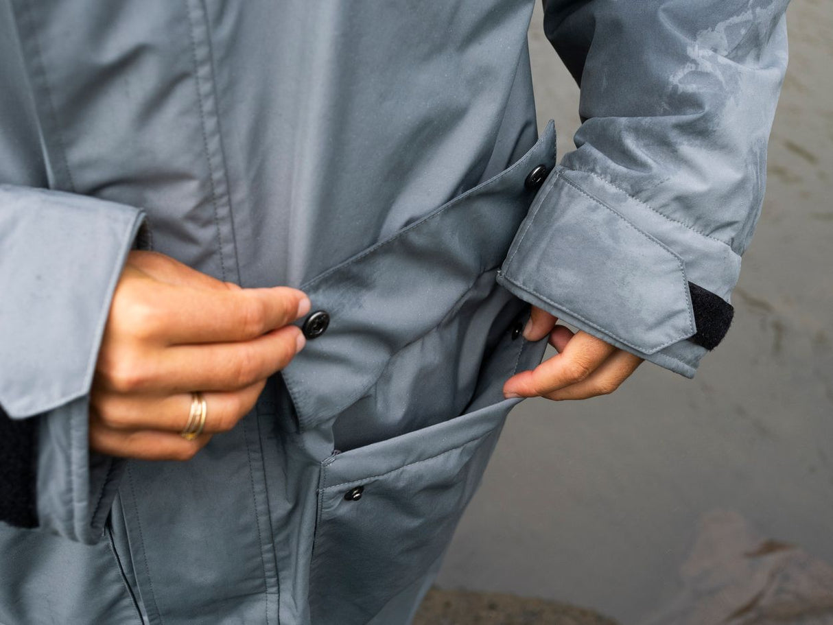 ION Storm Coat unisex 2026 in Grau, Detailansicht Vorderseite mit Taschen und Reißverschluss
