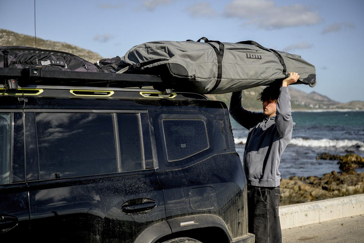 ION Wing Gearbag Core 2024 beige Transporttasche auf Autodachträger am Strand montiert