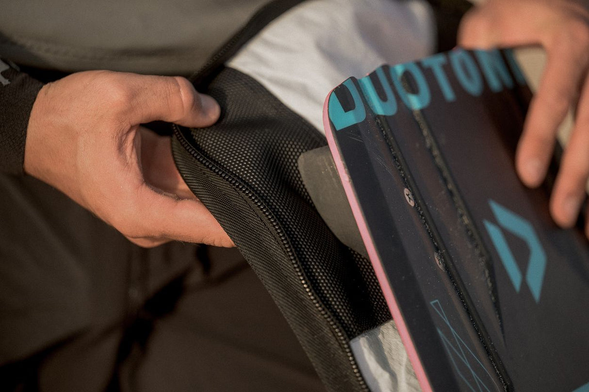 ION Twintip Boardbag Core 2024 in Schwarz mit Blau, Detailaufnahme der gepolsterten Innenseite und des Griffs beim Tragen
