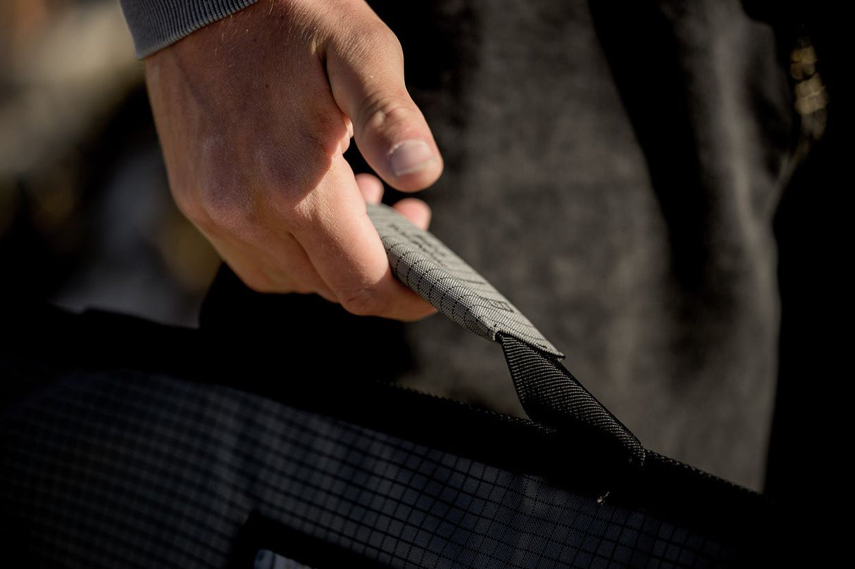 ION Prone Foil Boardbag Core 2026 schwarze Tasche mit Griff, Detail der robusten Materialstruktur in Nahaufnahme