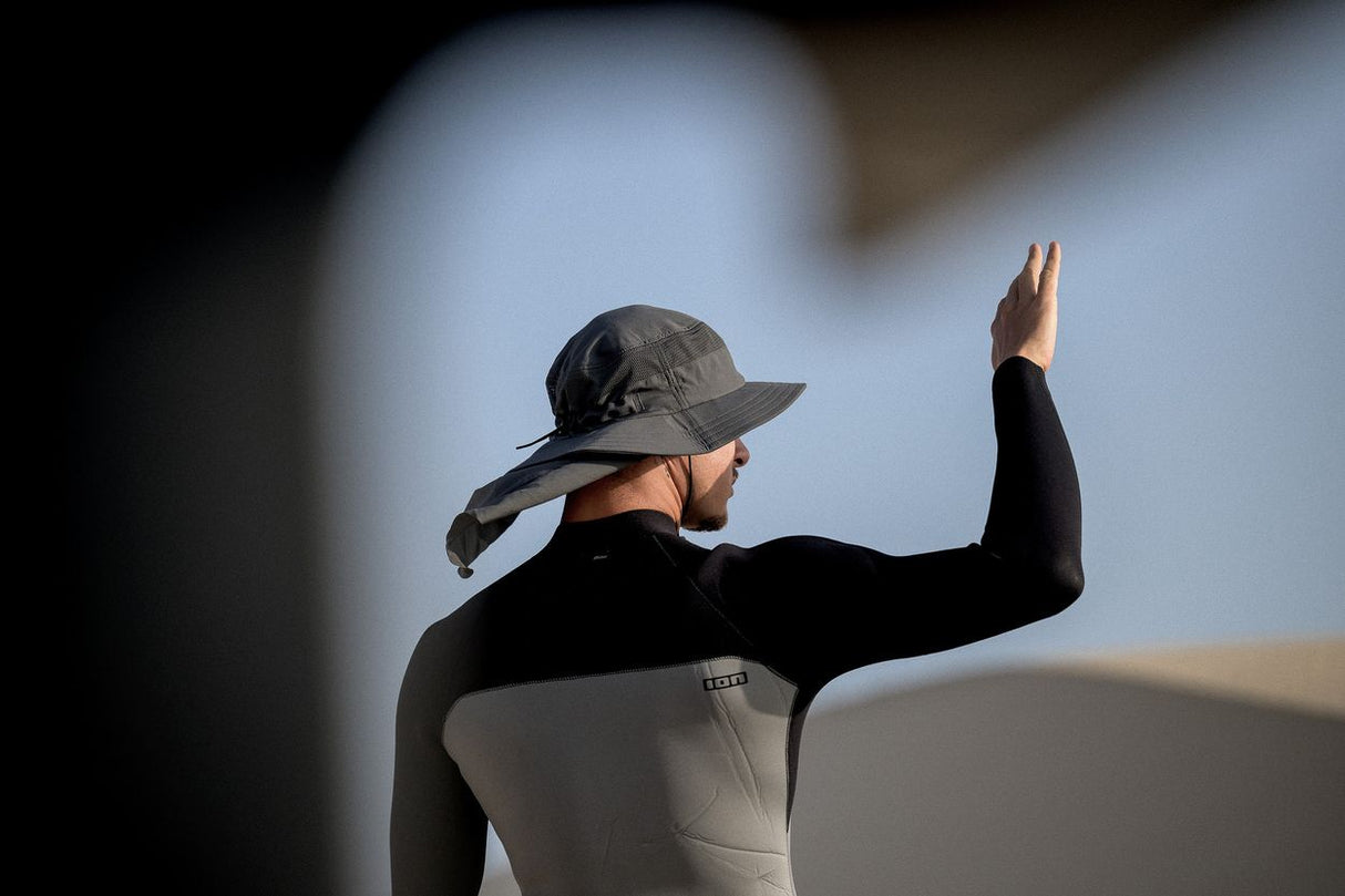 ION Safari Hat PRO 2026 schwarz, Seitenansicht auf Person mit Neoprenanzug, funktionaler Sonnenschutz mit Nackenbereich