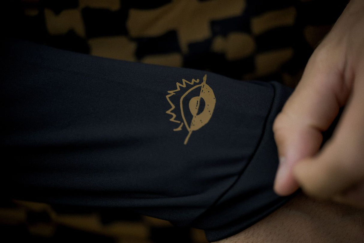 ION Rashguard Maze 2026 in Schwarz mit goldenem Logo, Detailaufnahme des Ärmels