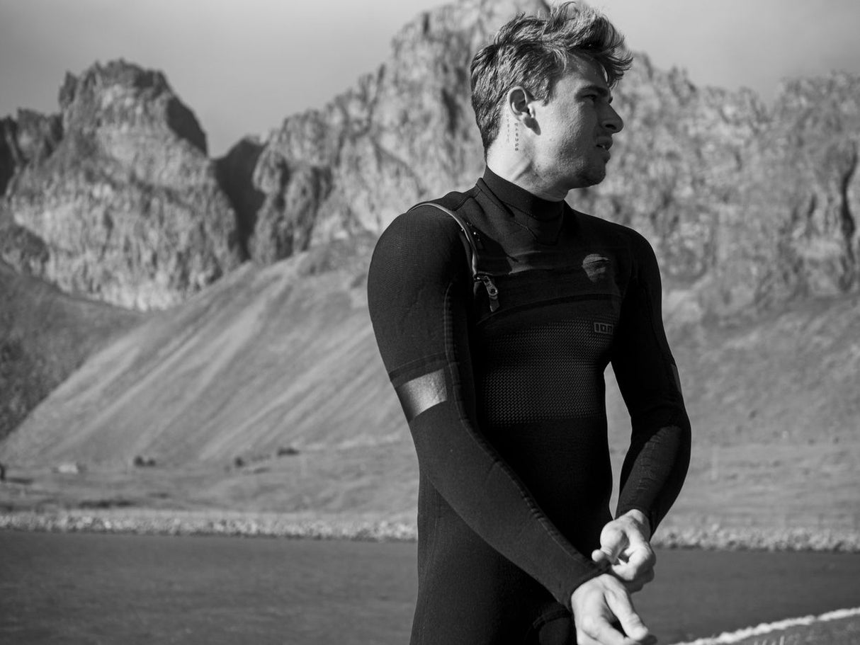 ION Seek Select 4/3 Front Zip Neoprenanzug in Schwarz mit Frontreißverschluss, Seitenansicht eines Mannes am Wasser