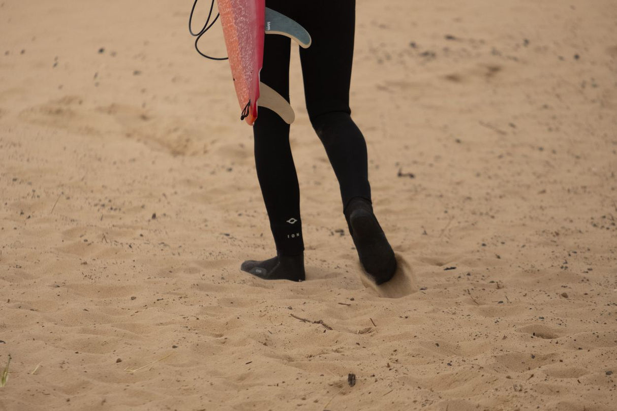 ION Seek Core 5/4 Neoprenanzug mit Kapuze und Front-Reißverschluss für Herren, schwarz, am Strand getragen