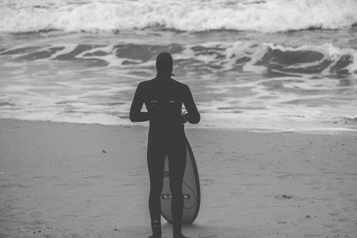 ION Seek Core 5/4 Neoprenanzug mit Kapuze und Front-Zip für Männer, schwarz, am Strand von vorne