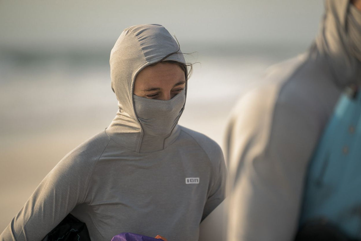 ION Storm Pro Wetshirt 2026 grau mit Kapuze, Gesichtsschutz und ION Logo, Frontansicht am Strand