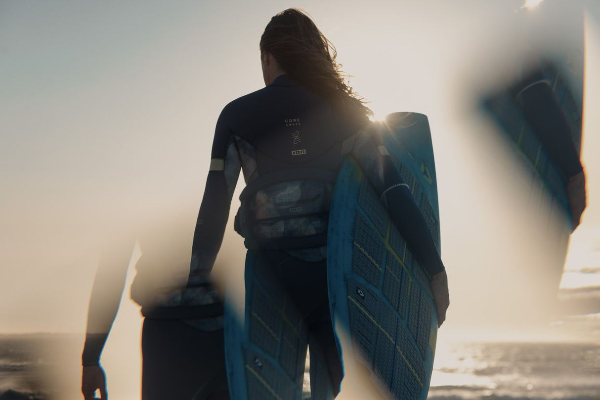 ION Sol Curv 2026 Kiteboard blau, Rückansicht mit Sportler im Wasser, Detailansicht des Boards