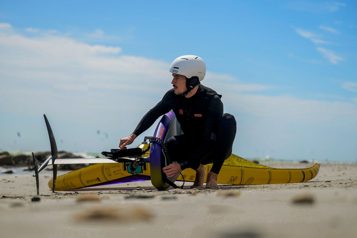 ION Hüftgurt 2026 schwarzer Neopren-Hüftgurt, getragen beim Kitesurfen am Strand mit gelb-violettem Kite