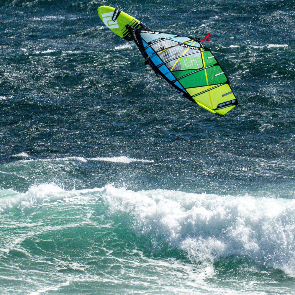 Patrik 5-Wave Kite in Neongelb und Grün beim Kitesurfen auf dem Meer, Draufsicht über Wellen