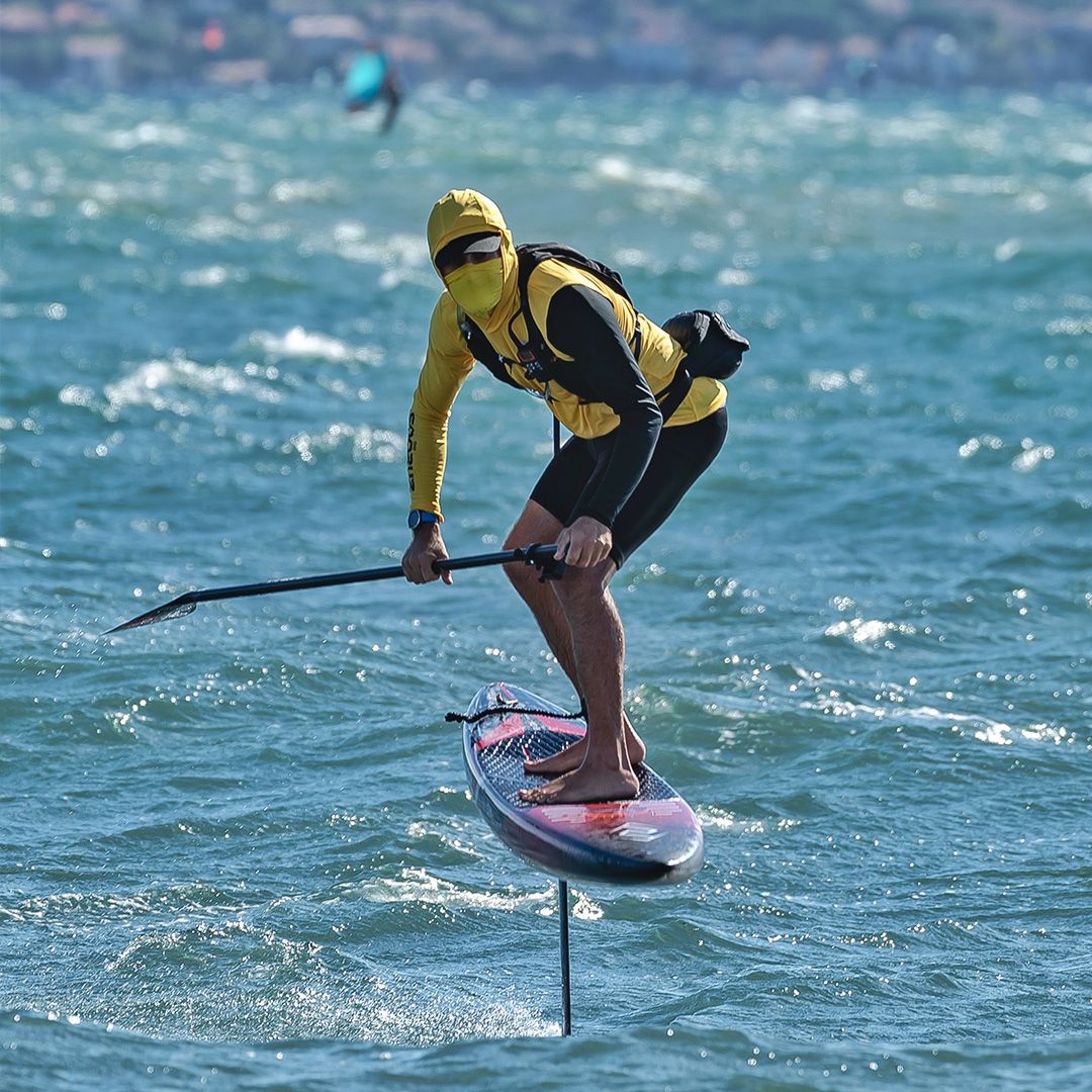 CHASE DW-R Downwind Racing Foil Board, gelb-schwarzer Neoprenanzug, Athlet in Aktion auf dem Wasser