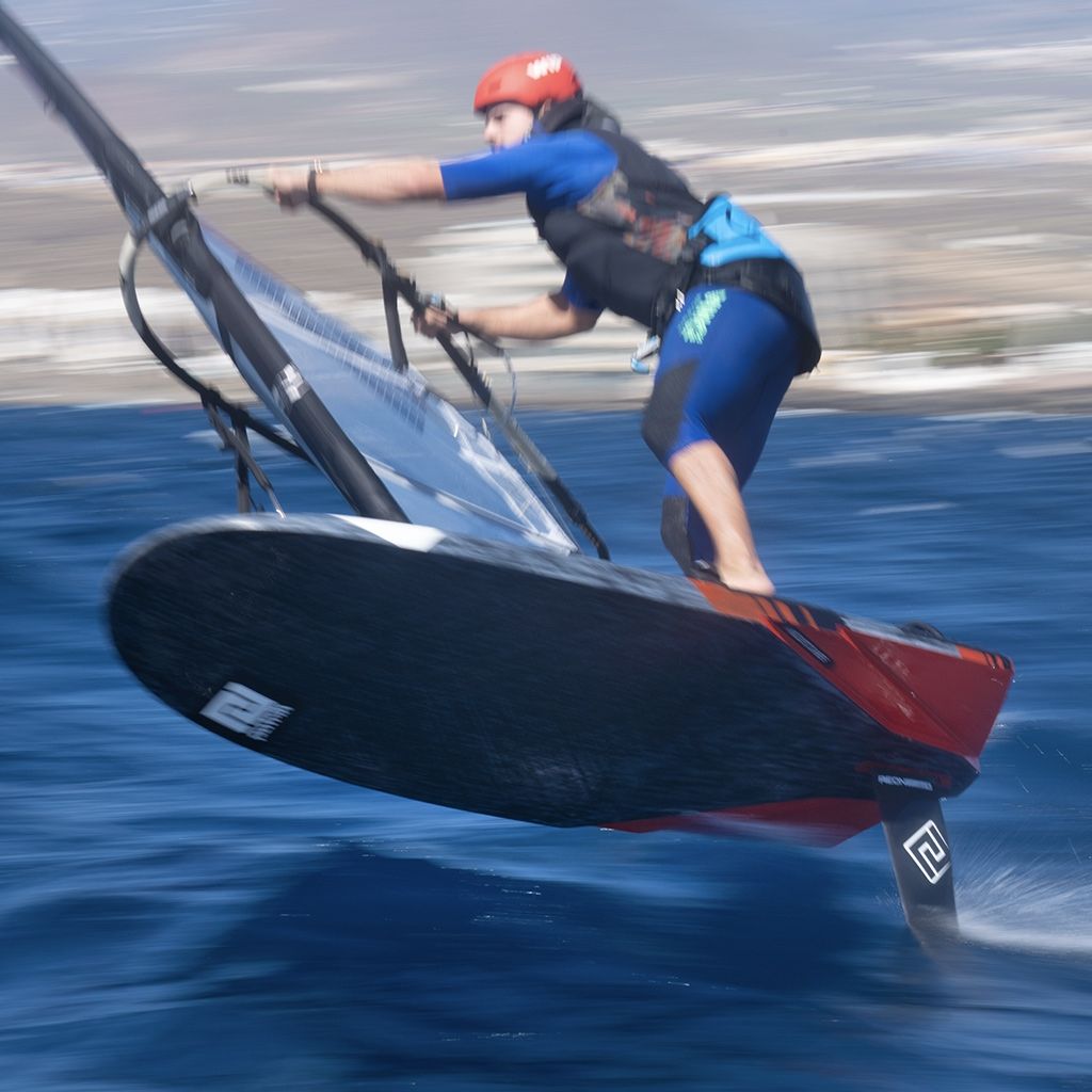 Patrik Foil Comp Gen3 Kitefoil in Aktion auf dem Wasser, Athlet in blauem Neopren beim Kiteboarden