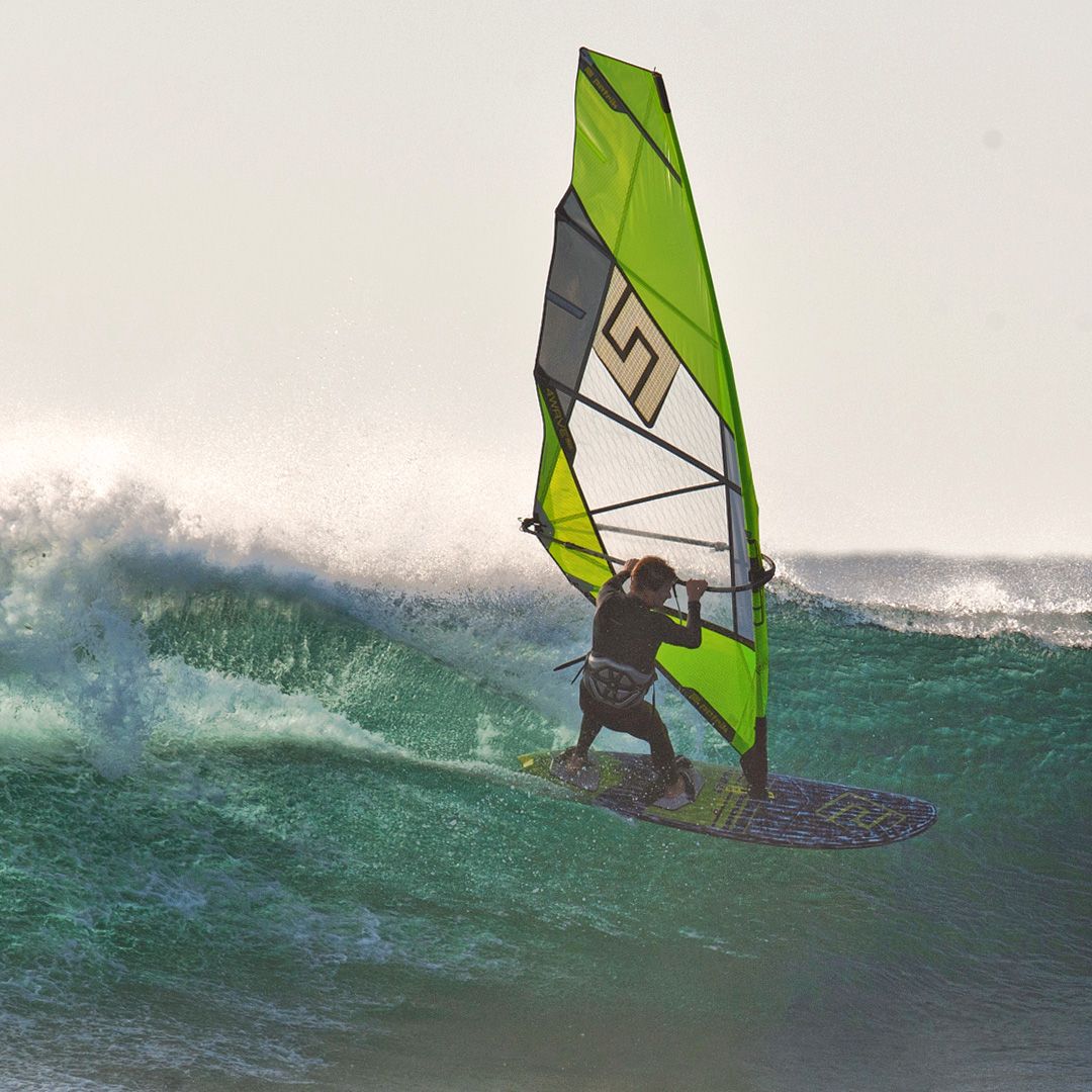 Patrik F-Wave Windsurfboard in Grün und Grau mit Segel, Surfer in Welle in Aktion