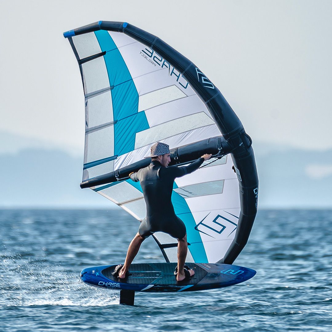 Chase WB-ML Midlength Foilboard blau-weiß mit Segel, Foiling-Action auf dem Wasser