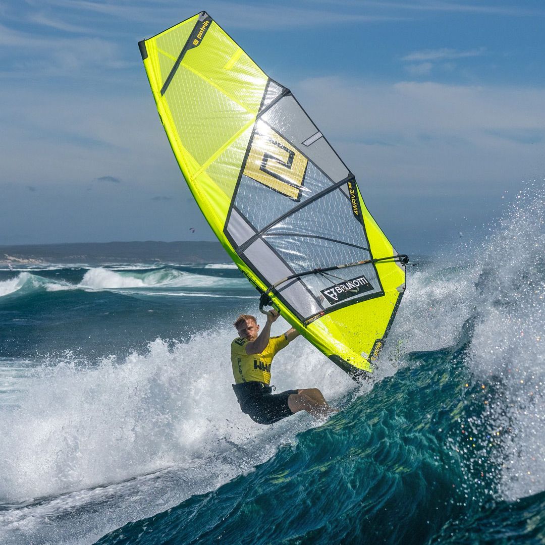Patrik QTS-Wave Windsegel neongelb-grau, in Aktion auf dem Wasser, Windsurfer in Welle, Frontalansicht