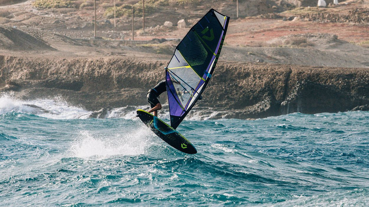 Duotone Skate D/LAB Waveboard in Blau-Schwarz mit Segel, Windsurfer auf Welle in Aktion