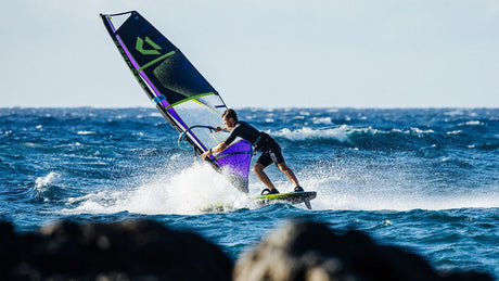 Duotone Sail Idol 2027 Windsurfegel in Blau und Grün, Athlet beim Windsurfen auf dem Meer in Aktion