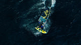 Duotone Sail Idol 2027 Waveboard mit gelbem und blauem Design, Draufsicht auf Wasser in Aktion