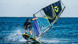 Duotone Sail Idol 2027 Windsegel in Blau und Gelb, Windsurfer in Aktion auf dem Wasser, Seitenansicht