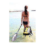 OverBoard Classic 20L wasserdichter Rucksack in Gelb und Schwarz, getragen beim Wassersport am Strand