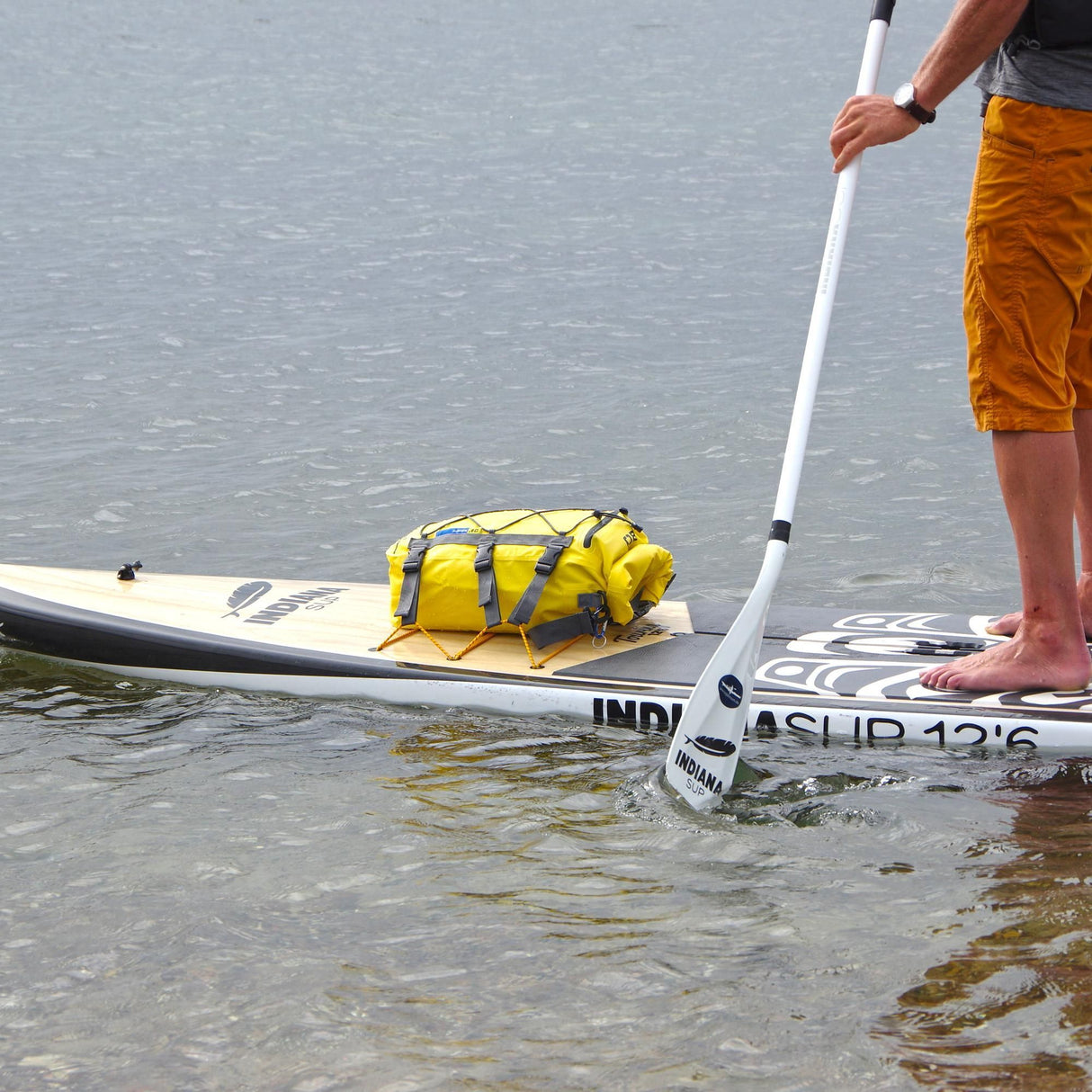 OverBoard wasserdichte SUP Kajak Tasche in Gelb auf Stand-Up-Paddleboard am Wasser befestigt