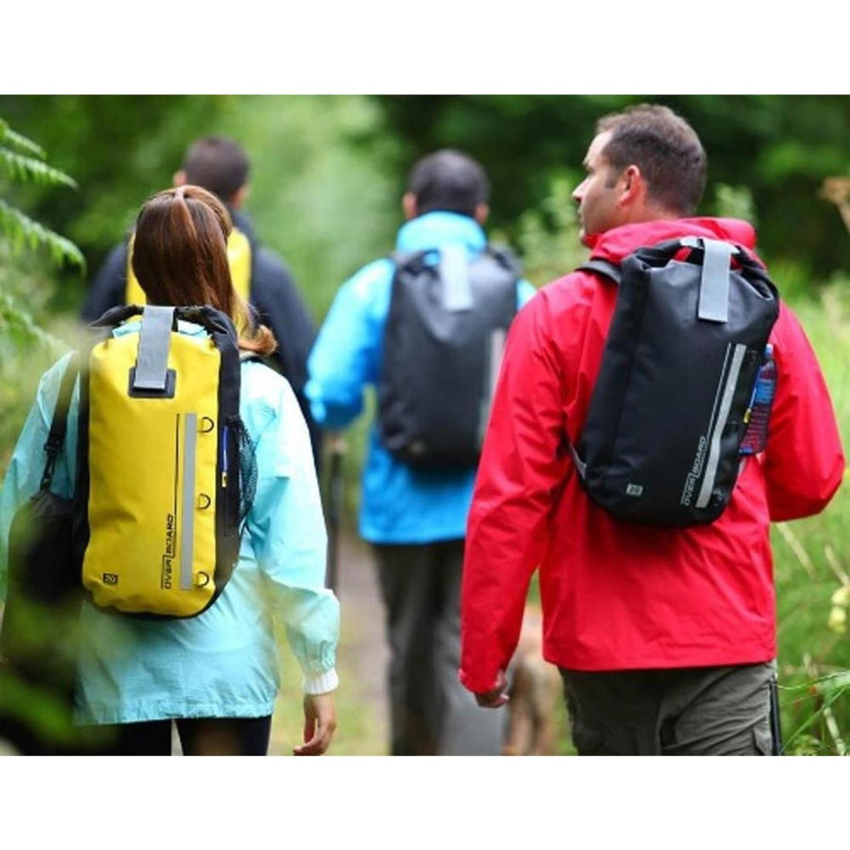 OverBoard wasserdichter Rucksack 20L in Gelb und Schwarz, getragen von Wanderern in der Natur, robuste Kunststoffmaterialien
