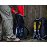 OverBoard wasserdichter Rucksack 30L schwarz mit Schultergurten, in Gebrauch neben Wasserflasche gezeigt
