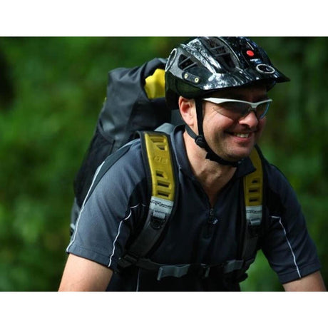 OverBoard wasserdichter Rucksack Pro 20L in Schwarz-Gelb, getragen von Radfahrer mit Helm, seitliche Ansicht