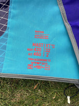 Duotone S-Pace 6.6 2026 Kiteboard Oberseite in Türkis und Blau mit roten Spezifikationen, Draufsicht auf Gras