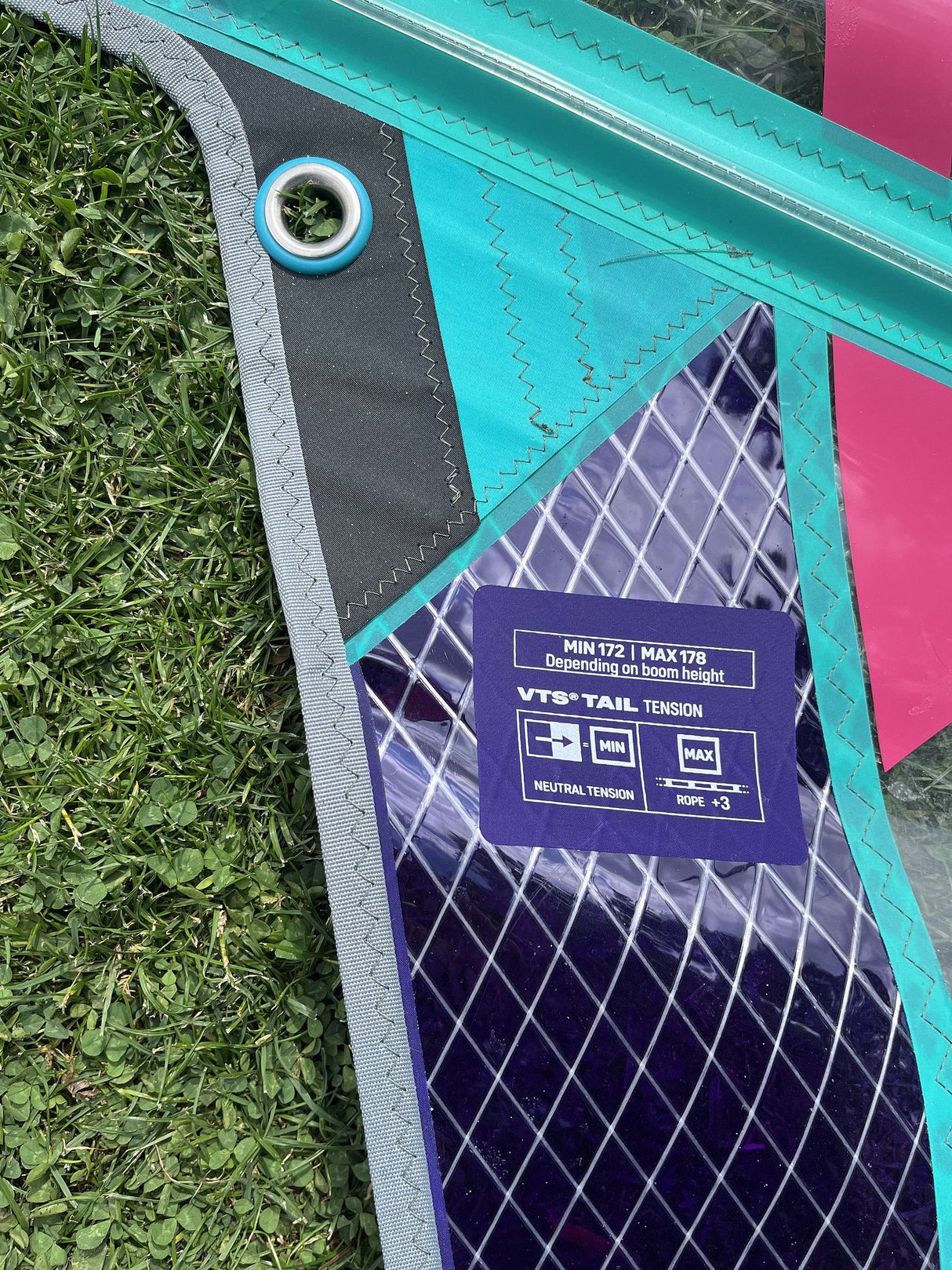 Duotone X Pace 5.8 2026 Kiteboard türkis-pink mit Rauten-Muster, Draufsicht auf Gras