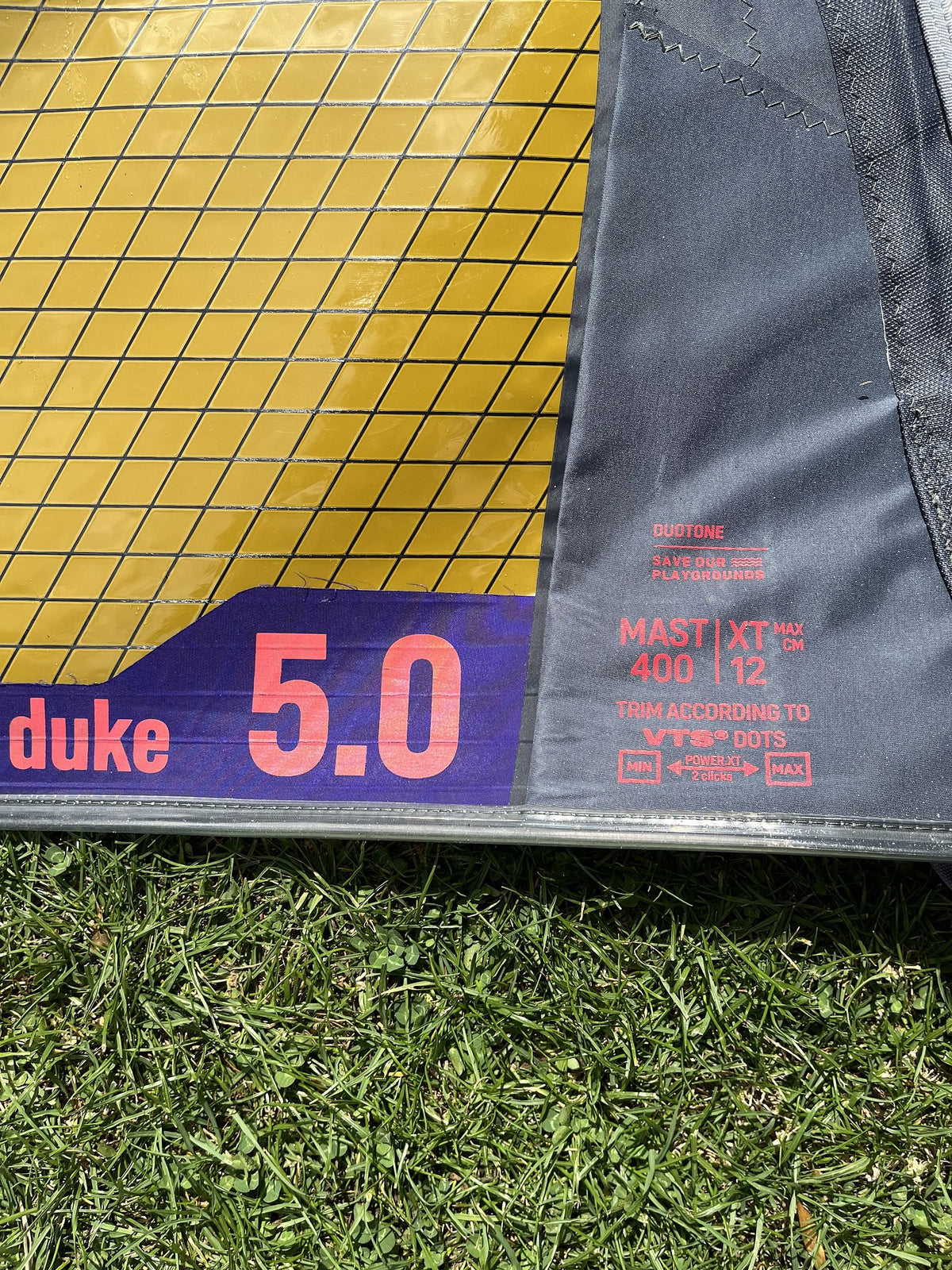 Duotone Duke 5 2026 Kitesegel gelb und grau, Detail der Segelkante mit Größenbezeichnung auf Gras