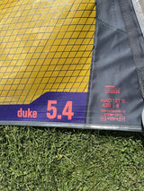 Duotone Duke 5.4 Kite gelb-blau mit Mastband auf Gras, Detailansicht des Segels und der Beschriftung