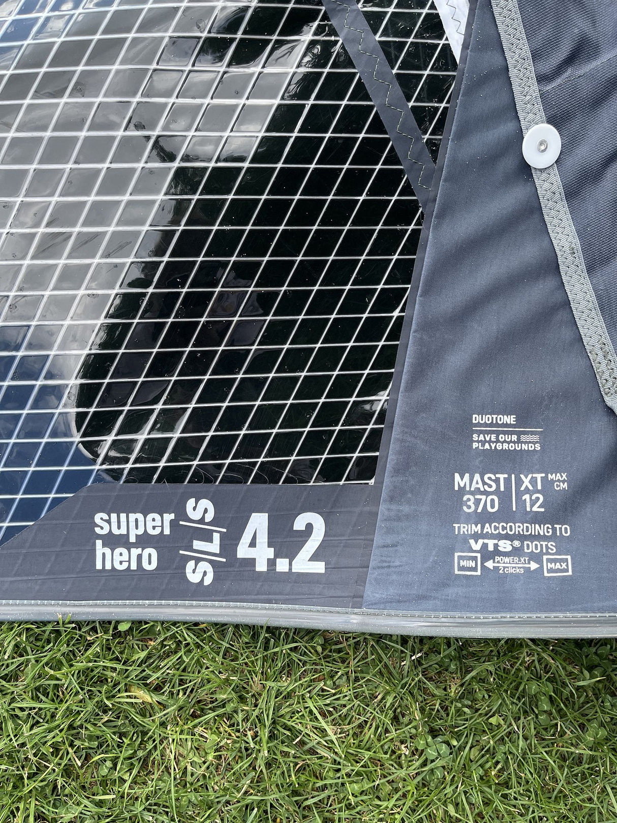 Duotone Super Hero SLS 4.2 2026 Kitesegel Duotone-blau mit schwarzem Netzdesign, Detailansicht von oben auf Gras