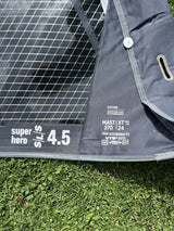 Duotone Super Hero SLS 4.5 Kiteboard grau-schwarz mit Netzstruktur, Detailansicht auf Gras