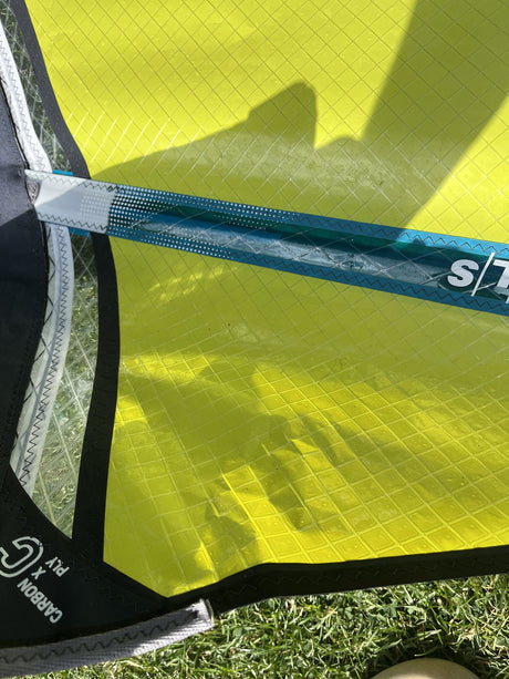 Duotone Super Hero SLS 4.5 2026 Kiteboard neongelb mit dunkelblauem Mast, Detailansicht auf Gras