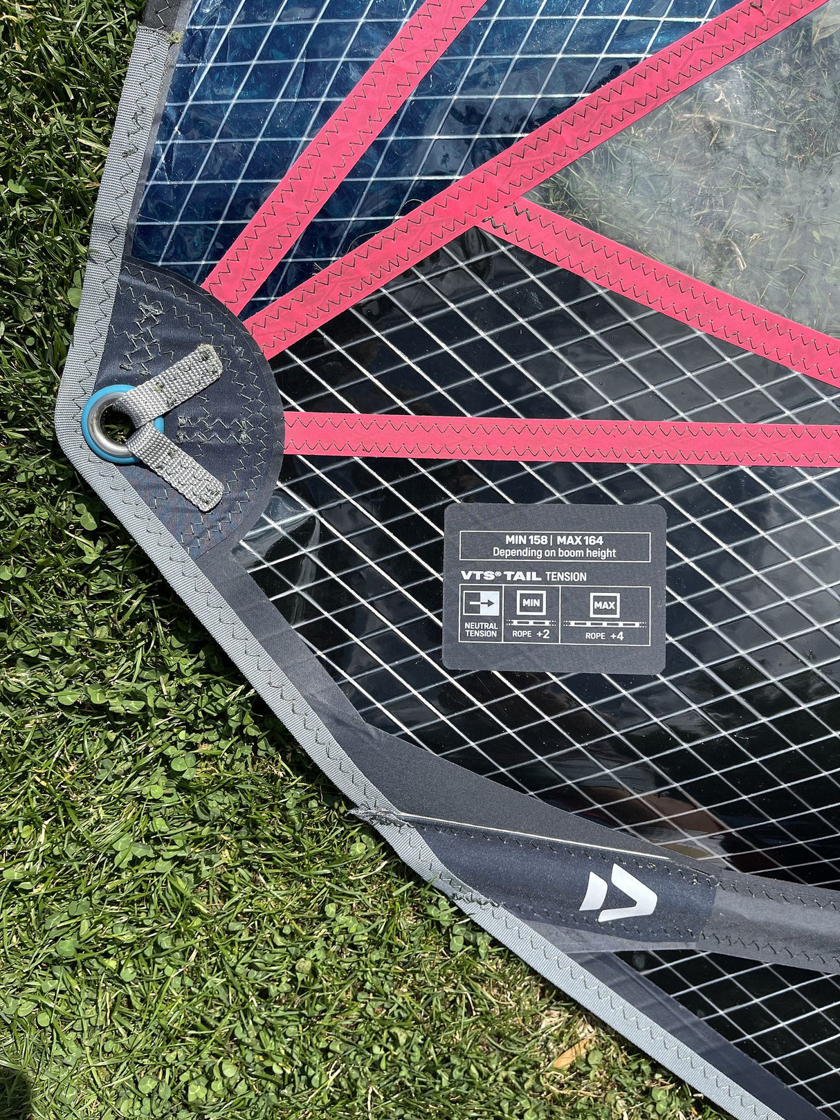 Duotone Super Hero SLS 4.7 2026 Kiteboard mit pinken Streben und schwarzem Netzgewebe, Draufsicht auf Gras