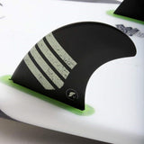 Futures Twin Tri Fin Set T1 Alpha mit schwarzer Basis, grünen Flossen und grau strukturiertem Design auf Surfboard