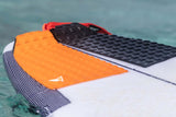 Roam Footpad Deck Grip Traction Pad 2-tlg, orange und schwarze Griffpolster auf Surfboard im Wasser