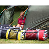 OverBoard Duffel Bag Pro wasserdichte Tasche in Rot und Gelb, auf Gras vor Zelten liegend, robustes Design