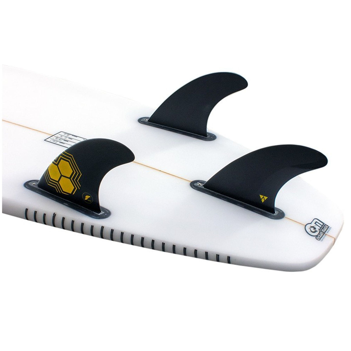 Futures AM2 Alpha Thruster Finnen Set mit drei schwarzen Flossen auf weißem Surfboard, gelbe Wabenstruktur sichtbar