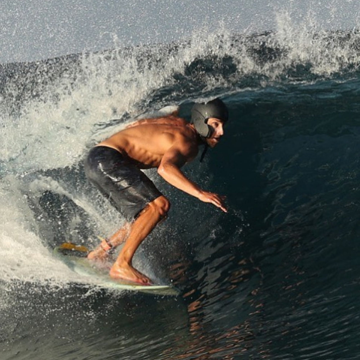 Simba Sentinel Wassersport Helm in Schwarz, getragen von Surfer auf Welle, Seitenansicht