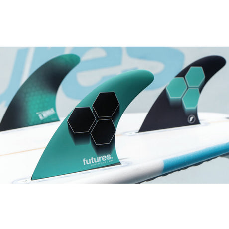 Futures AM1 Honeycomb Thruster Finnen Set in Türkis und Schwarz mit Wabenmuster-Design auf Surfboard