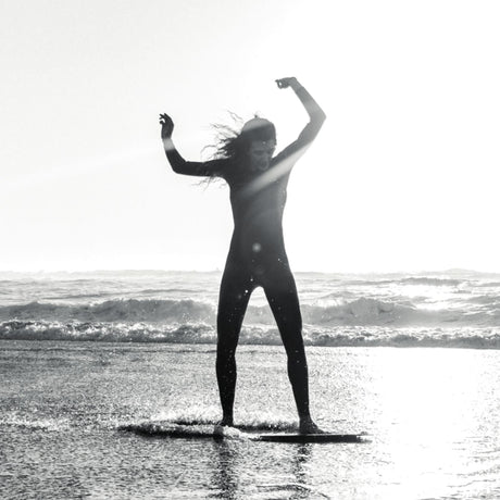 SkimOne Skimboard Wood Holz in Natur, Person mit Board im Meer, Frontalansicht