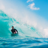 Wave Power Bodyboard Woop pink in Aktion auf Welle, Surfer paddelt im türkisen Meer
