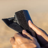 ROAM Dachauflage Surfboard Rund in Dunkelblau, rundformiges Neopren-Pad mit schwarzem Klettverschluss, in der Hand gehalten