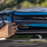 ROAM Dachauflage Surfboard Flach in Blau und Schwarz mit Befestigungsgurten auf Autodach montiert, Detailansicht